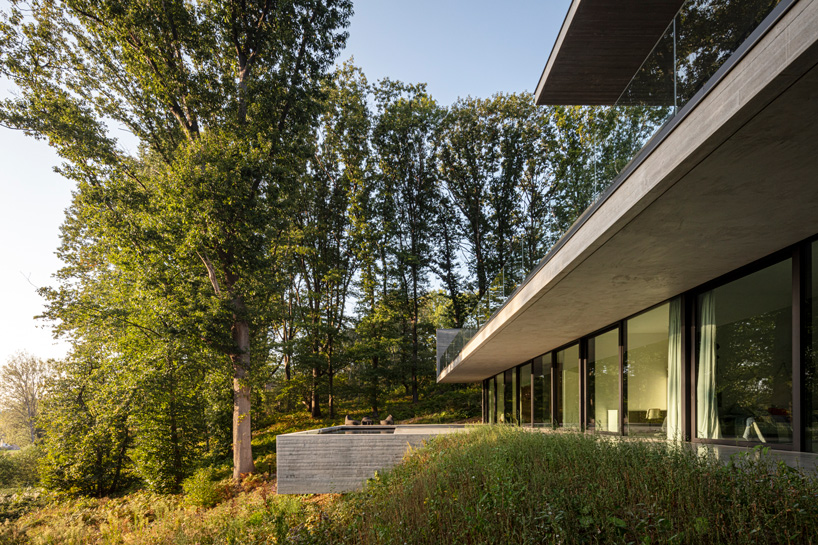 linear concrete residence by govaert & vanhoutte architects blends in belgian forest