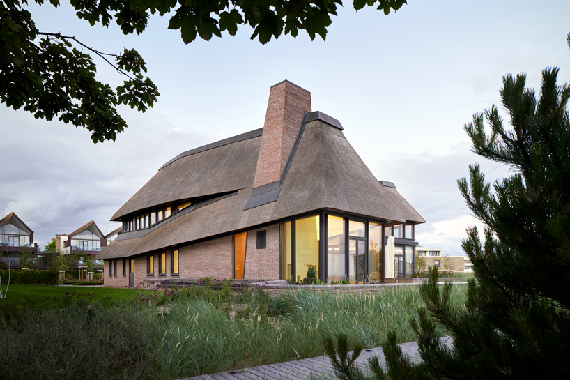 thatched hip roof tops hubschmitz architekten's house on föhr island, germany
