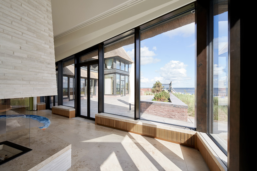 thatched hip roof tops hubschmitz architekten's house on föhr island, germany