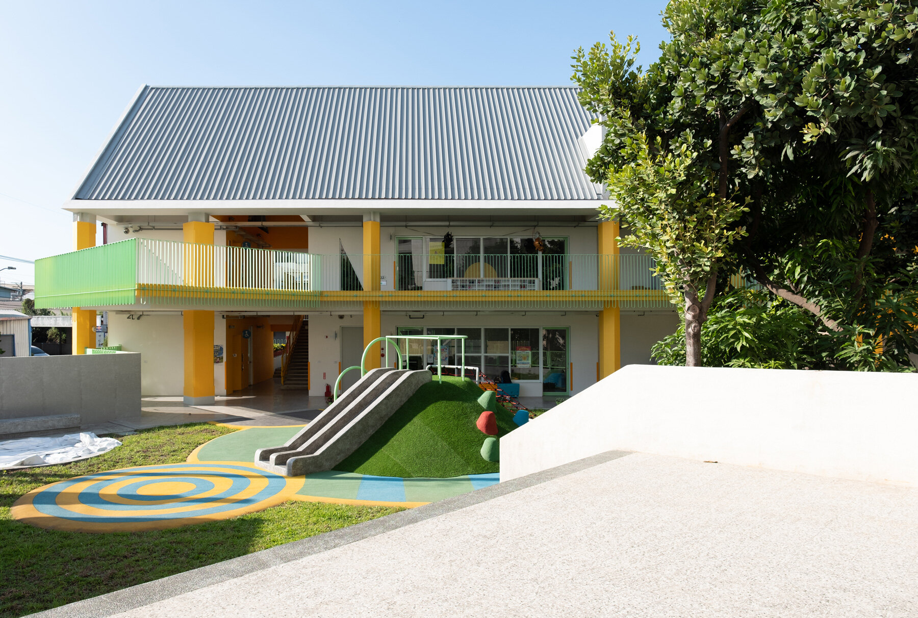 bright yellow columns complete ospacearchitects' tung yuan kindergarten in taiwan