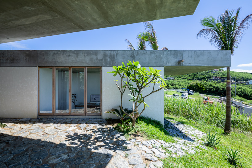 studio cochi architects' concrete house opens toward the lush landscape of okinawa island
