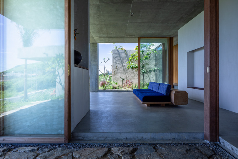 studio cochi architects' concrete house opens toward the lush landscape of okinawa island