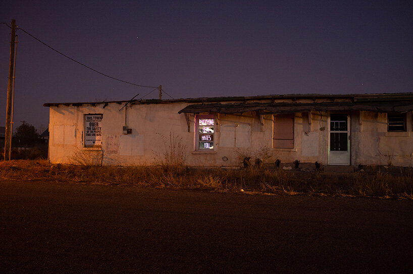 chris ramming and rob brill install ‘everyone hates you’ neon sign in marfa, texas