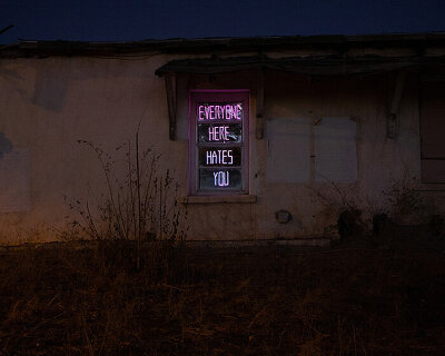 chris ramming and rob brill install ‘everyone hates you’ neon sign in marfa, texas
