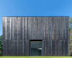 OLI architecture sets richard serra's london cross sculpture in charred wood pavilion in NY