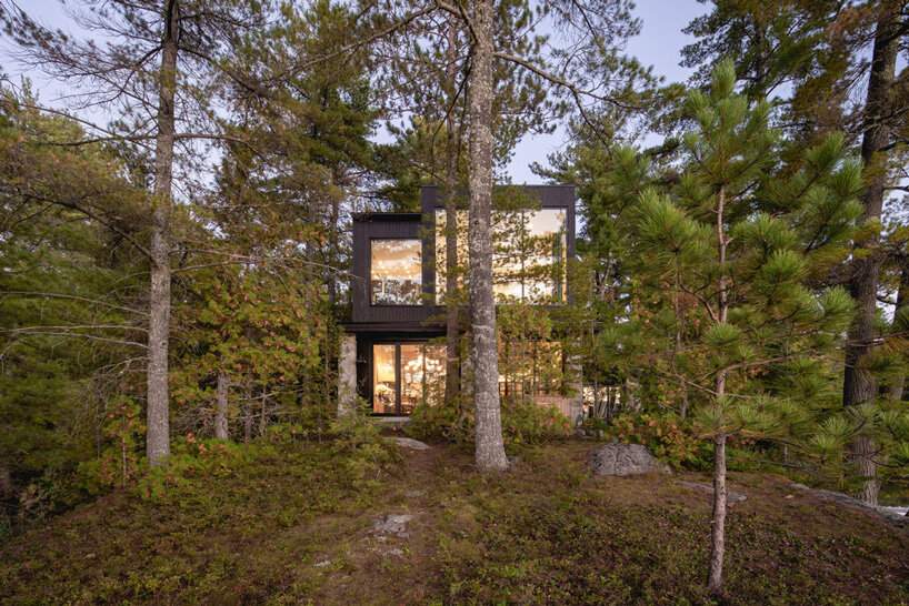 paul bernier architecte tops rustic log cabin in canada with monolithic wood-clad extension