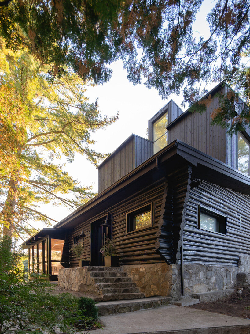 paul bernier architecte tops rustic log cabin in canada with monolithic wood-clad extension