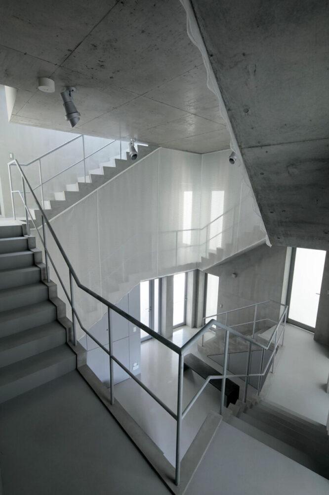 two concrete spiral staircases define TA+A's 'tokyo gasshuku-jo' share ...