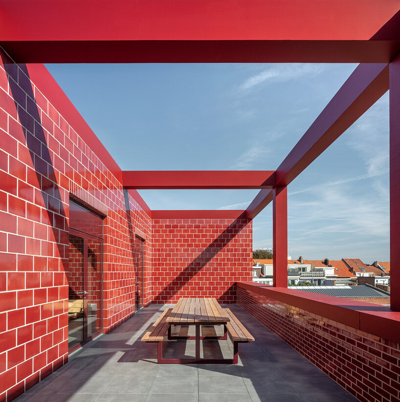 red façades + stacked volumes recall the function of this fire station in antwerp