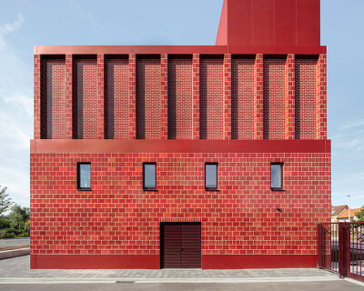red façades + stacked volumes recall the function of this fire station in antwerp