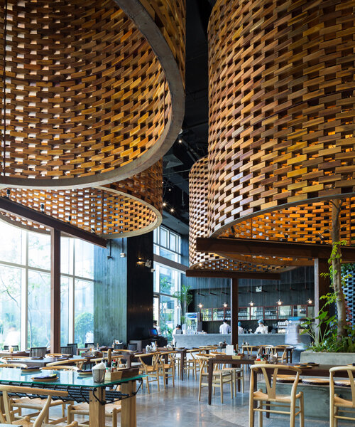 luminous wooden cylinders float above ODDO architects' 'pizza 4P' in hanoi