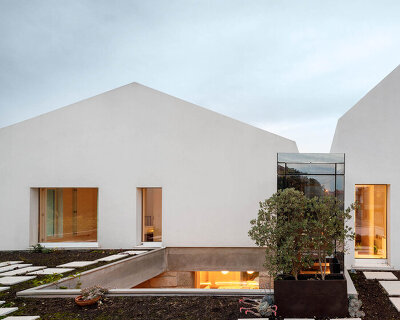 paulo merlini architects recovers derelict portuguese farmhouse with 'casa rio'