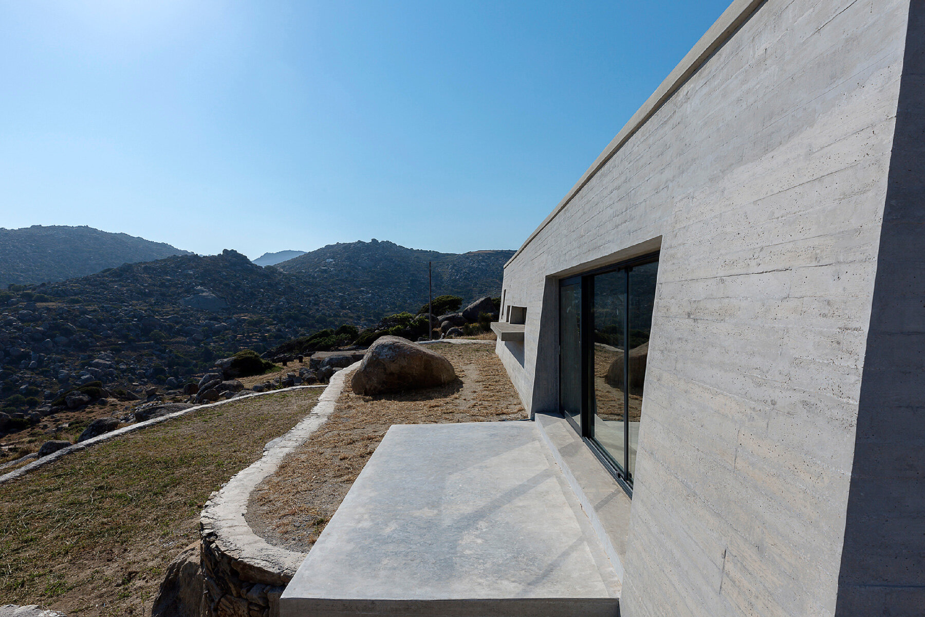 aristides dallas architects sets three-volume house between the rocks of tinos island
