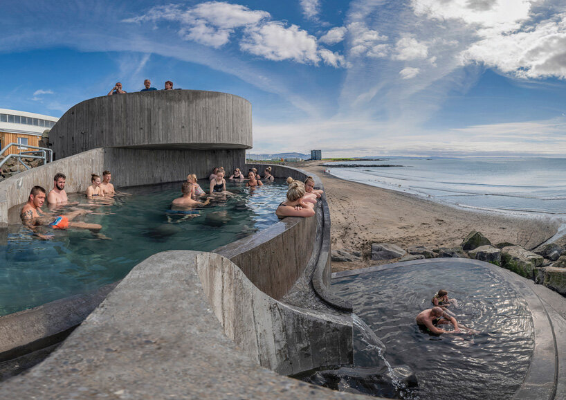 basalt architects nestles 'guðlaug baths' into a rocky breakwater barrier in iceland