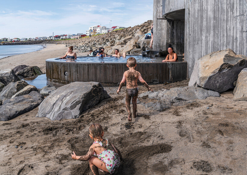 basalt architects nestles 'guðlaug baths' into a rocky breakwater barrier in iceland