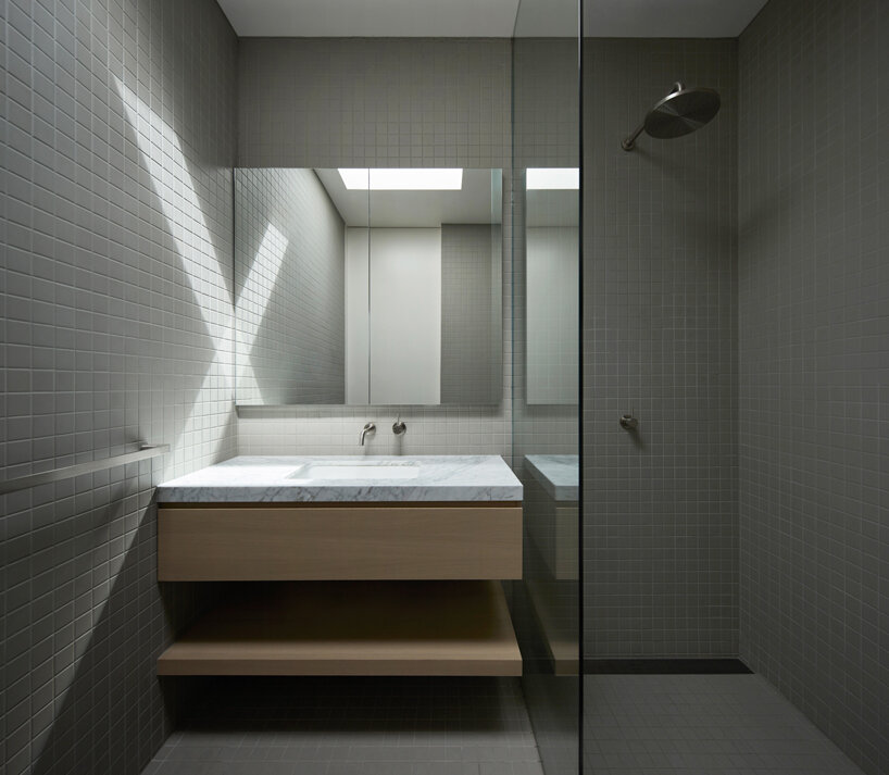 a minimalist weekend house projects out over a hillside in wye river, australia