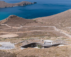 sinas architects embeds a snaking stone summer house into serifos island in greece
