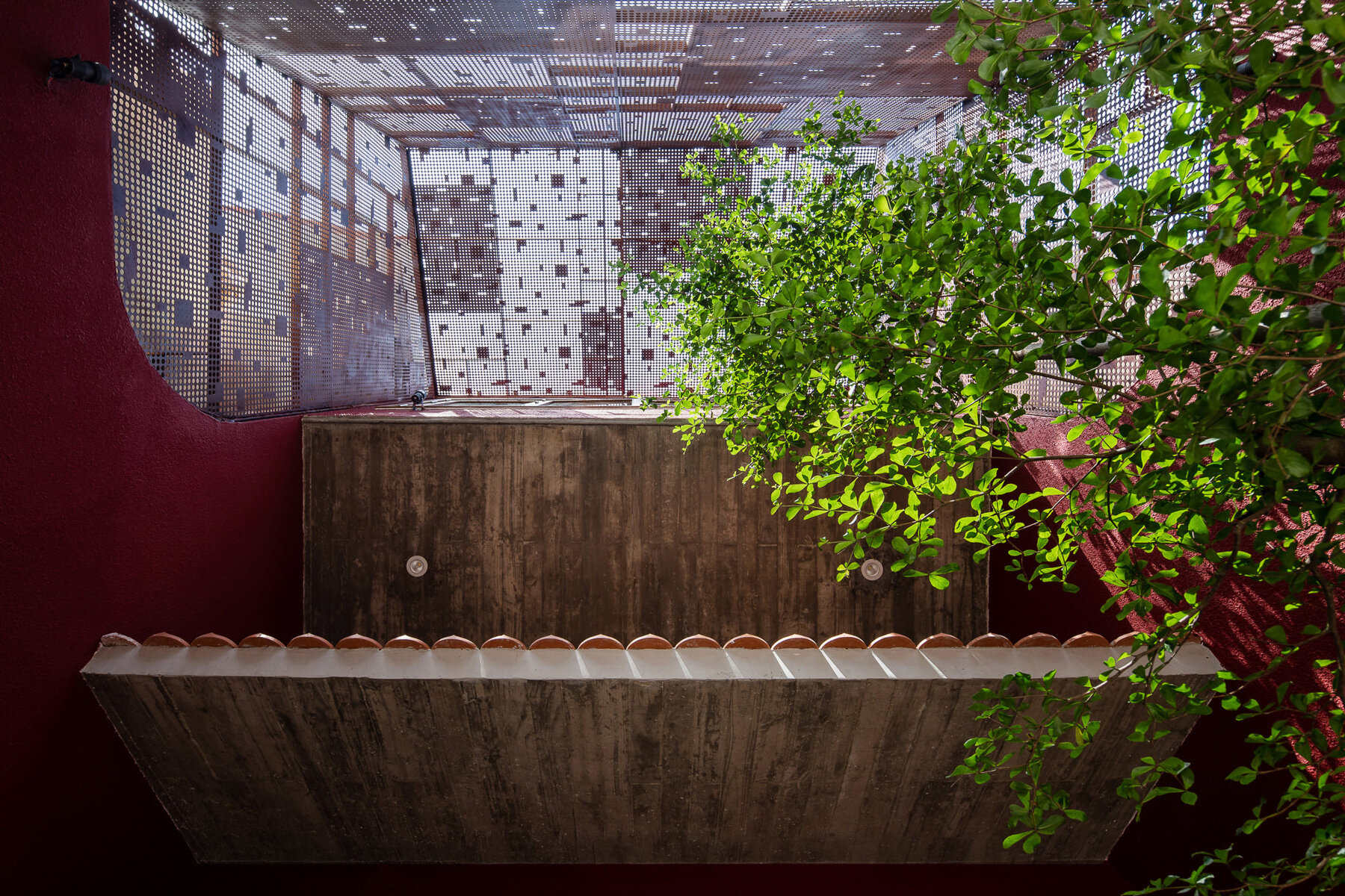 AD9 architects completes vietnamese house with perforated façade + sloped roof garden