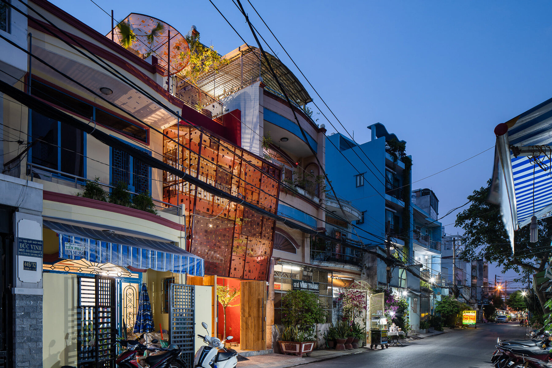 AD9 architects completes vietnamese house with perforated façade + sloped roof garden