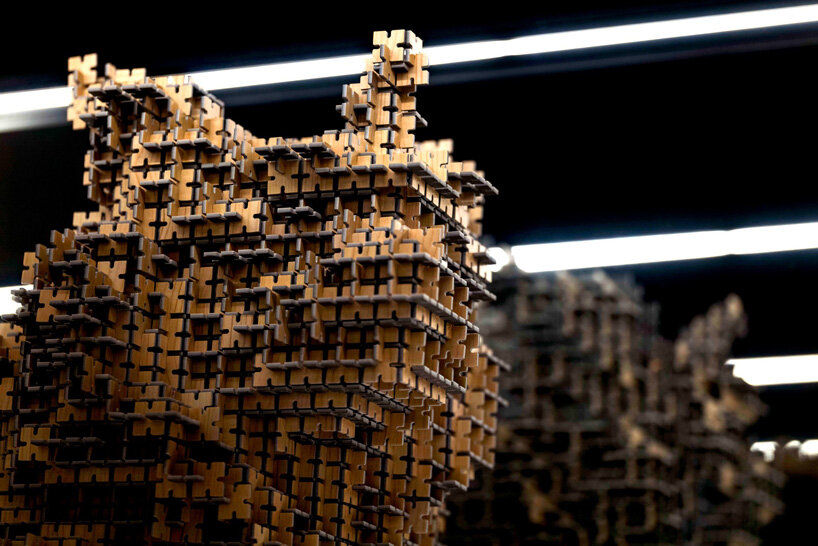 thousands of artificial wood pieces compose secca's puzzle sculpture 'A↔︎UN'