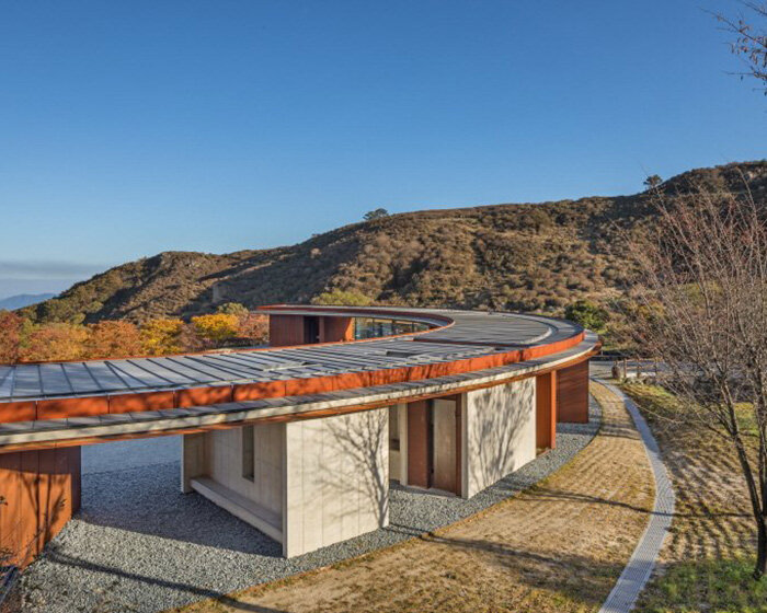 D.LIM architects blends crescent moon-shaped rest area into korean mountains