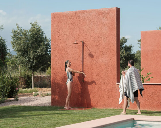 a pink 'lover's house' settles into the rugged landscape of mallorca