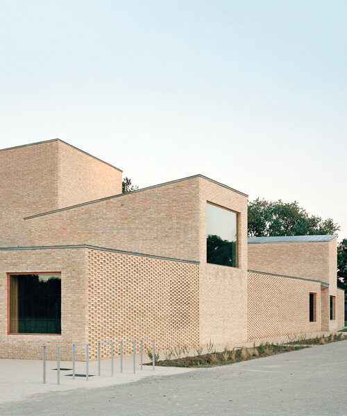 raum architects builds monolithic cultural center in france using terracotta bricks + concrete
