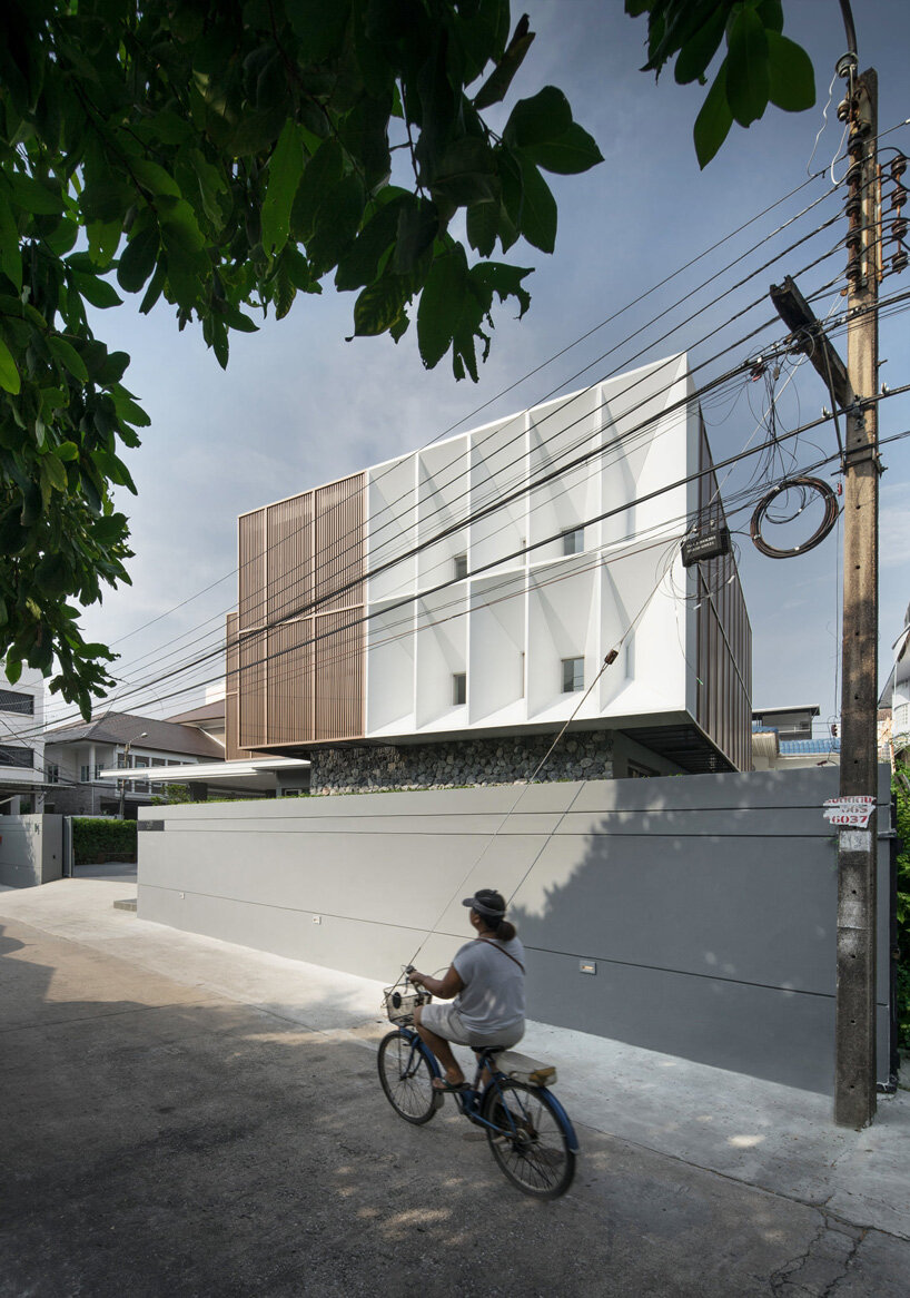 perspacetive renovates house in thailand with wooden battens + natural stone walls