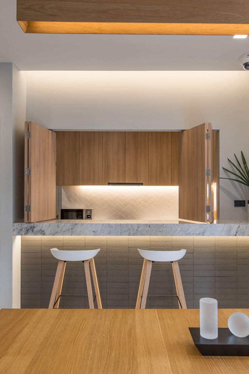 perspacetive renovates house in thailand with wooden battens + natural stone walls