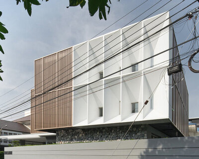 perspacetive renovates house in thailand with wooden battens + natural stone walls