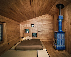 studioata restores stone hut in valle dell’orco with warm, chestnut wood interventions