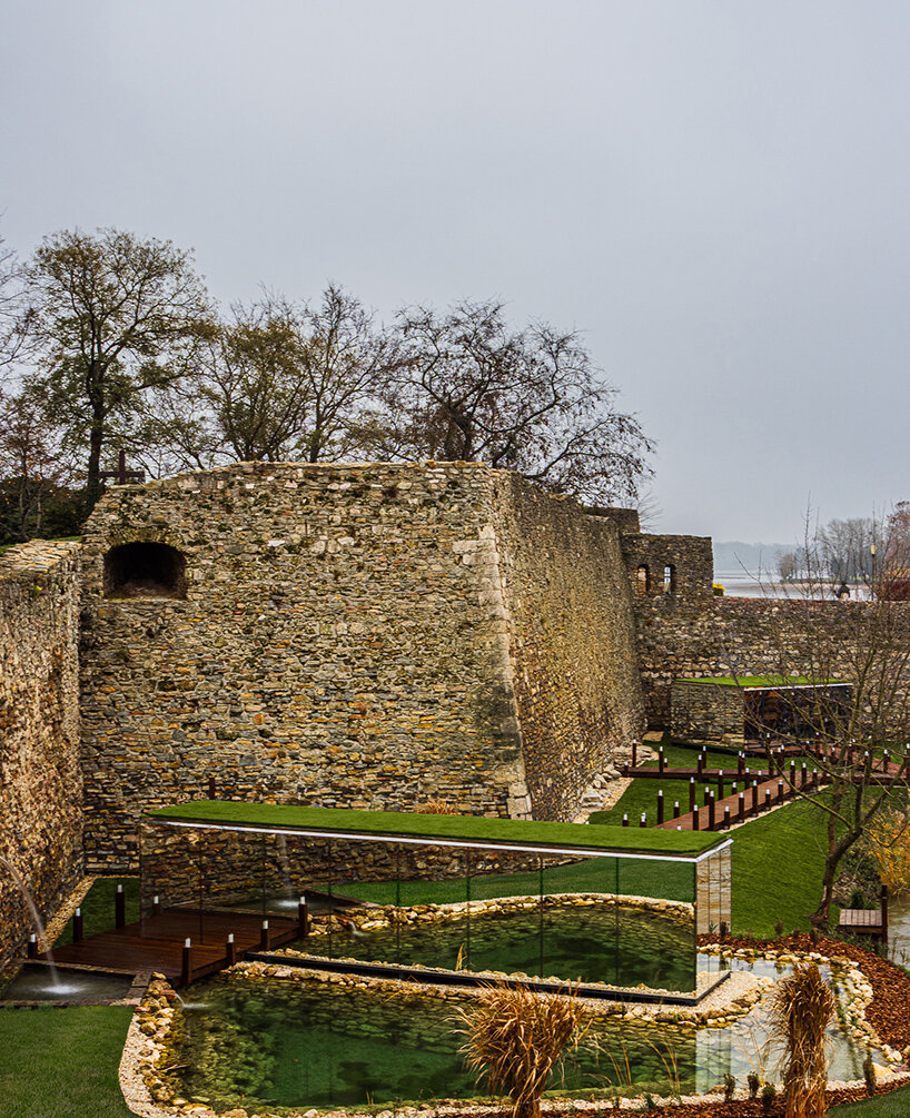 zoltan varro's mirrored spa occupies a 14th century castle moat in hungary