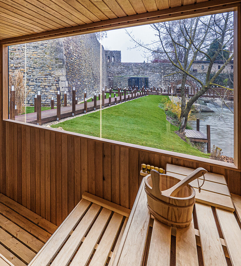 zoltan varro's mirrored spa occupies a 14th century castle moat in hungary