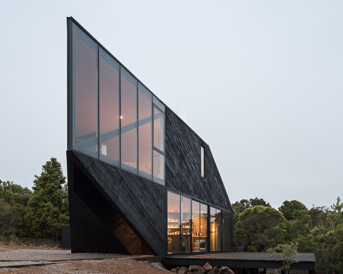 2DM's black timber-clad cabin points toward the sea on the chilean coastline