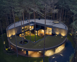 circular wooden house by mobius architekci blends into its pine forest surroundings in poland