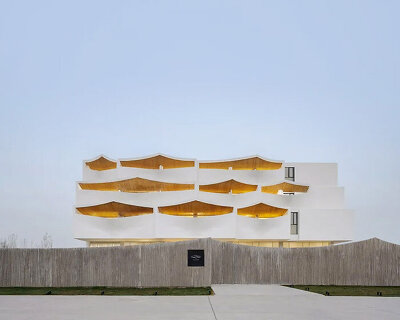 curved white wall façade adorns new hotel model in industrial site of china