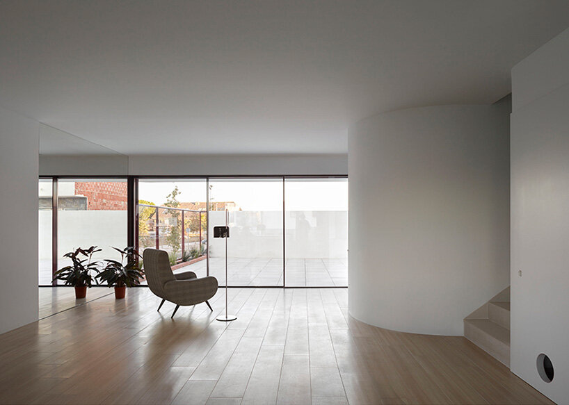 brick plinth contrasts with concrete curved mass in horma estudio's casa AA in spain