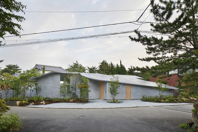 sculptural roof curves around trees in tomohiro hata's house in okuike ...