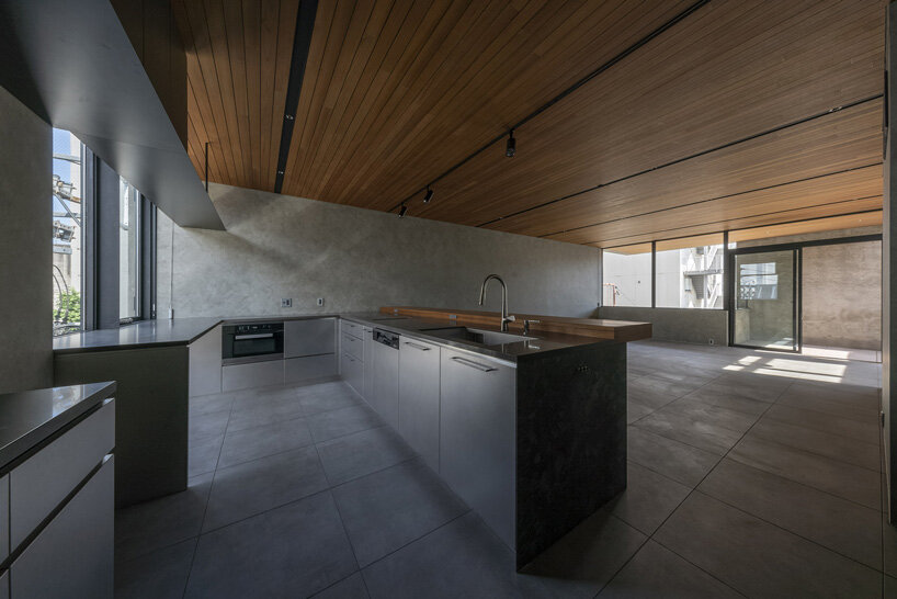 five-story atrium brings natural light into keitaro muto's concrete apartment building in japan