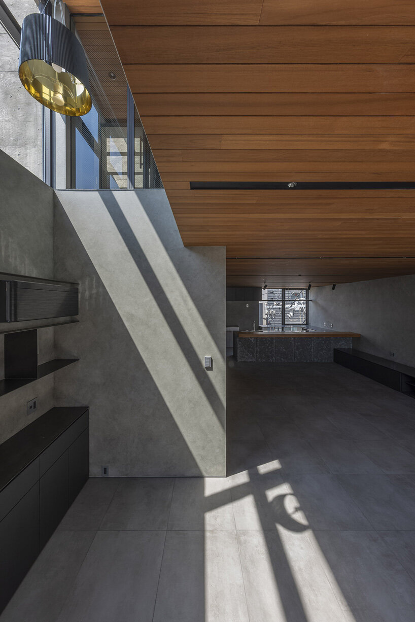 five-story atrium brings natural light into keitaro muto's concrete apartment building in japan