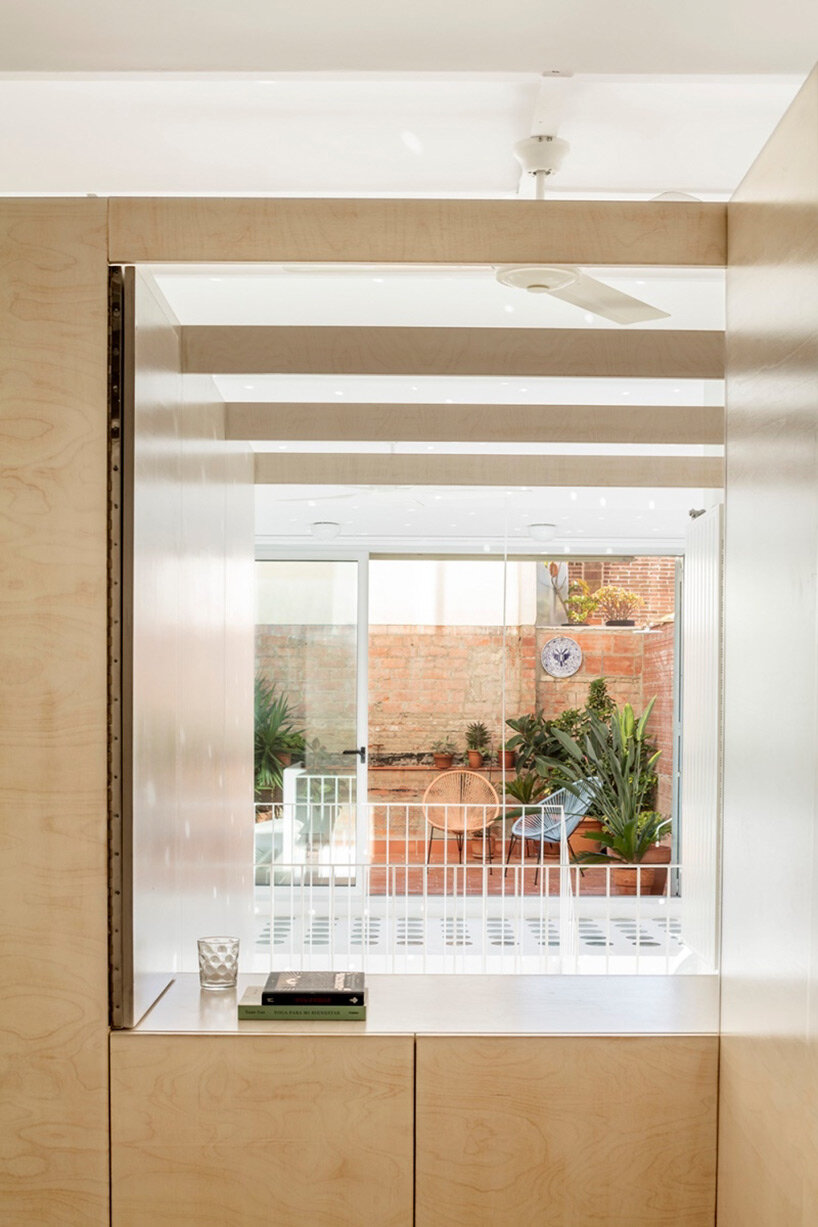 wooden boxes form the interior of this renovated mezzanine apartment by vora in barcelona