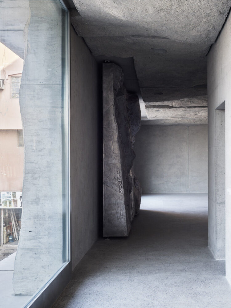 sandcasted concrete façade clads anne holtrop's green corner building
