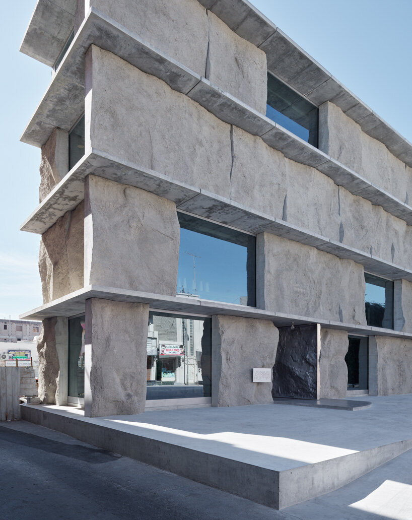 sand-casted concrete façade clads anne holtrop's green corner building in  bahrain