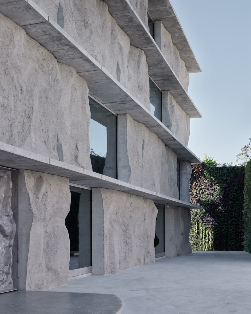 sand-casted concrete façade clads anne holtrop's green corner building in  bahrain