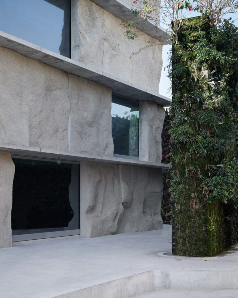sandcasted concrete façade clads anne holtrop's green corner building