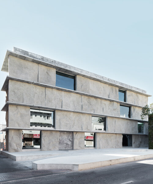 sand-casted concrete façade clads anne holtrop's green corner building in bahrain