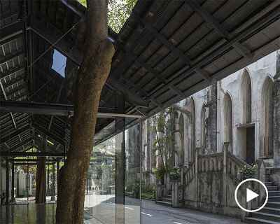 a glass + steel pavillion built around existing trees of a vietnamese cathedral