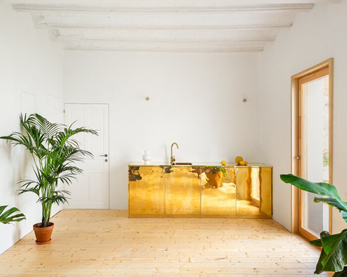 polished brass kitchen piece dominates this renovated 1920s apartment in spain