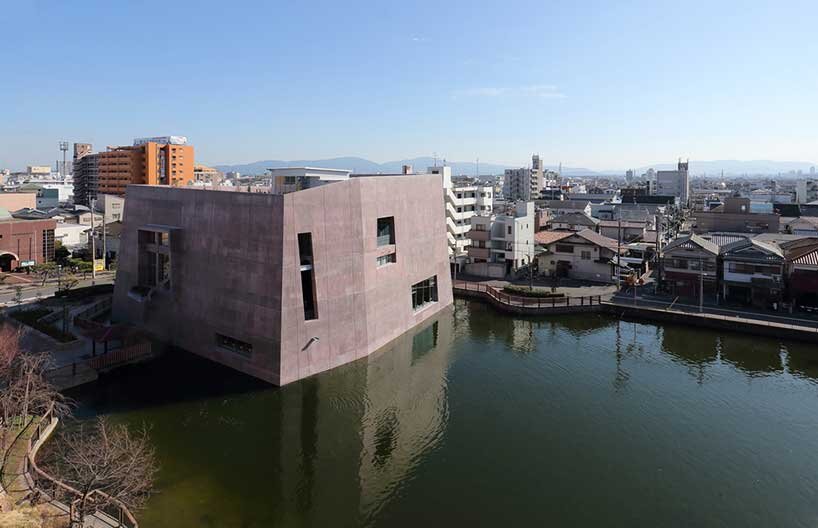 monolithic library extension by maru architecture floats on serene pond in matsubara, japan