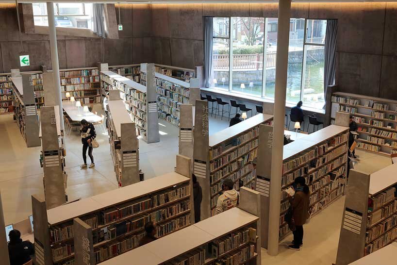 monolithic library extension by maru architecture floats on serene pond in matsubara, japan